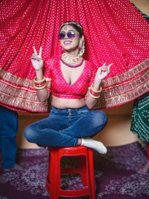 A playful Bengali bride in traditional attire with sunglasses, mixing tradition and modern style.