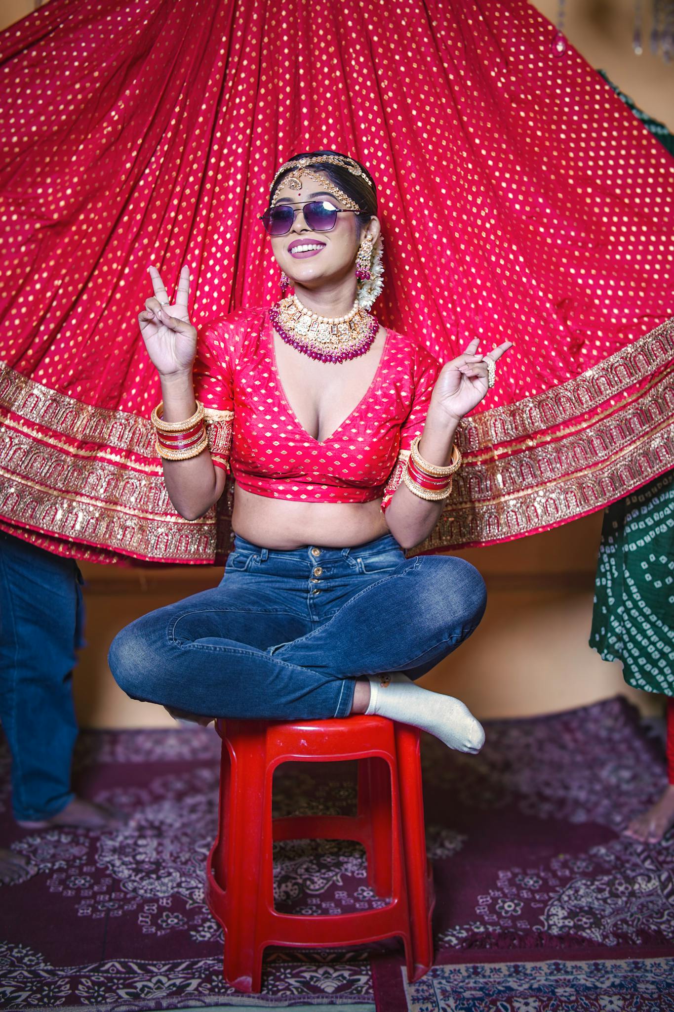 A playful Bengali bride in traditional attire with sunglasses, mixing tradition and modern style.