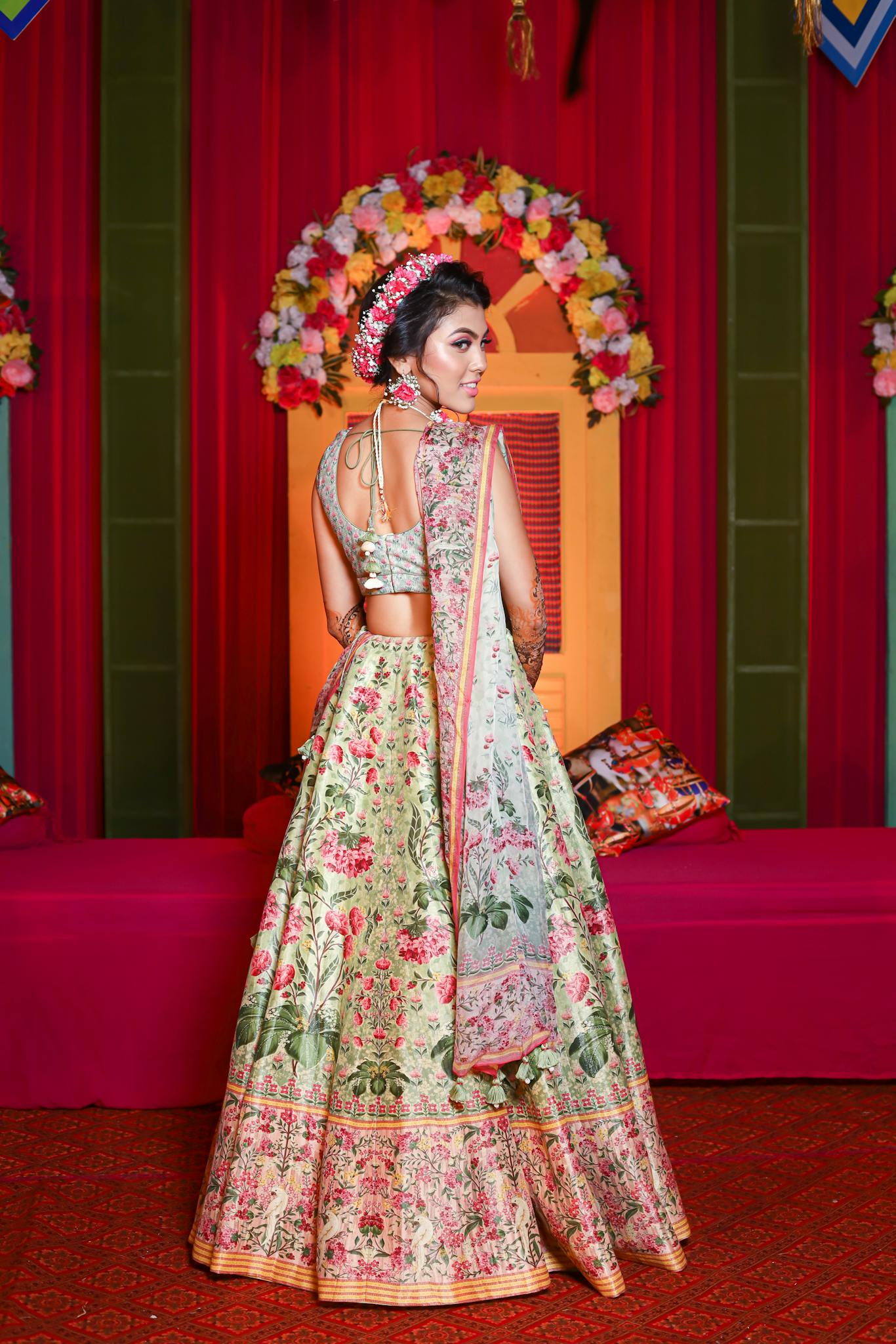A stunning Indian bride wearing a floral lehenga in a traditional setting, showcasing cultural elegance.