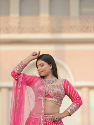 Stunning Indian bride in vibrant pink lehenga, posing gracefully at a historic Agra palace.